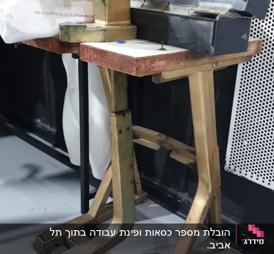 מכונת תפירה ומכבש על שולחן עץ